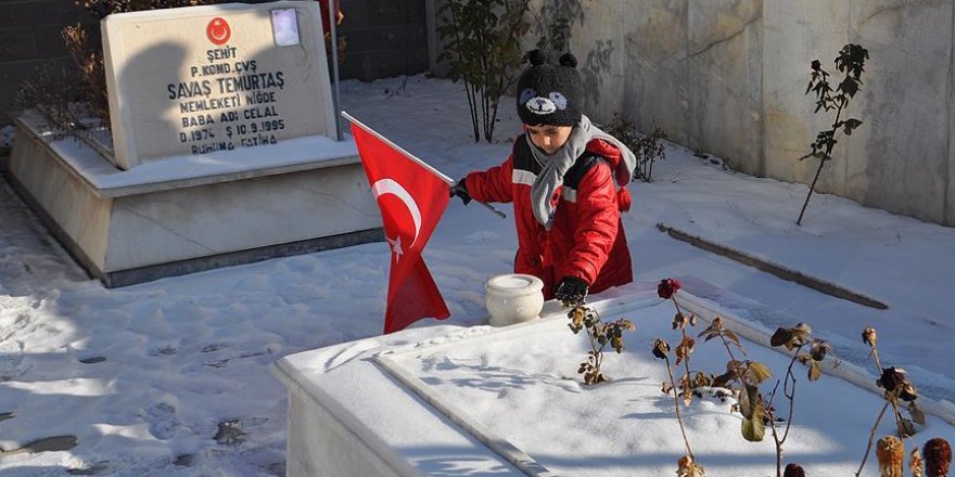 'Şehitler üşümesin' diye mezar taşındaki karları temizledi