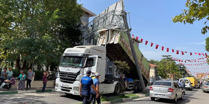 Seyir halindeki kamyon kasası açılınca yol levhasına takıldı