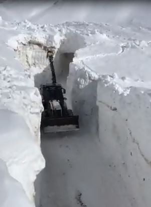 Kar kalınlığının iş makinelerinin boyunu geçtiği yolda zorlu çalışma