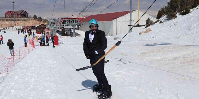 Kayak sezonunu takım elbiseyle snowboard yaparak uğurladılar