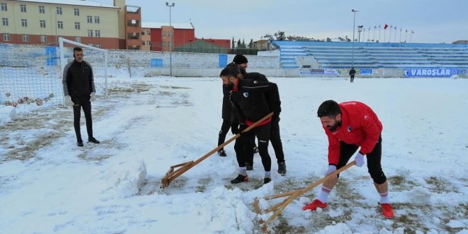Sporcular çim sahada kar küredi