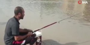 Göle dönen caddeye olta attı, balık tutmaya çalıştı