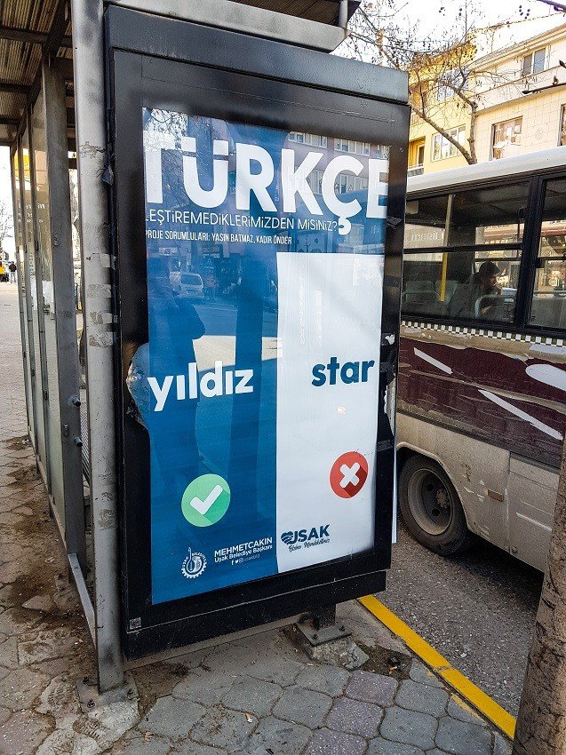 Astıkları afişlerle sokakta Türkçe eğitimi veriyorlar