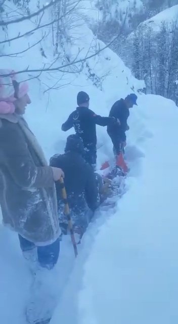 Karla kaplı yolda hastayı sedyeyle taşıdılar