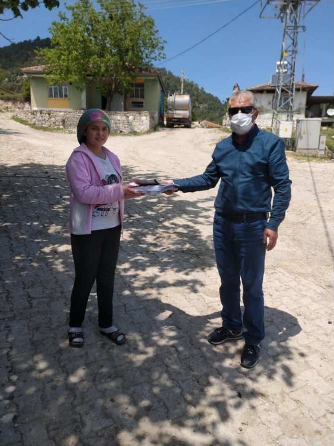 Müdür ve öğretmenler, öğrencilerine evlerinde kitap dağıttı