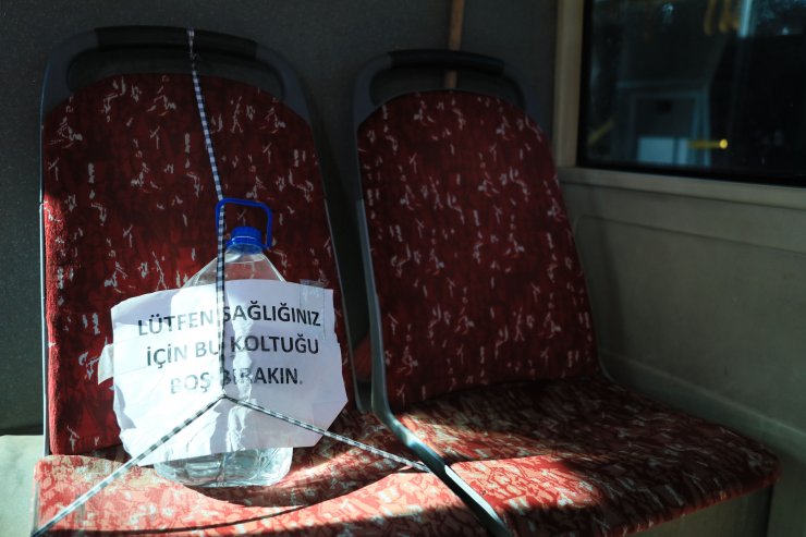 Otobüste 5 litrelik plastik su bidonuyla koronavirüs önlemi