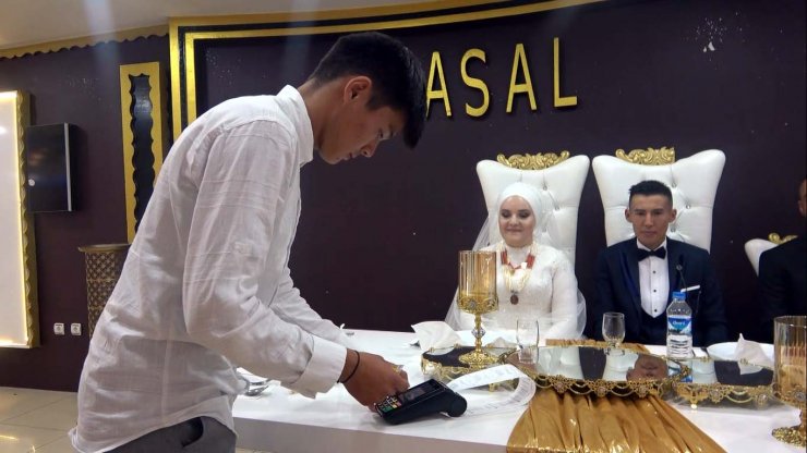 Kırgız çiftin düğününde aşıya dikkat çekmek için pos cihazıyla takı takıldı