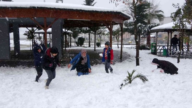 Lapa lapa yağan kar altında çocukların kartopu keyfi