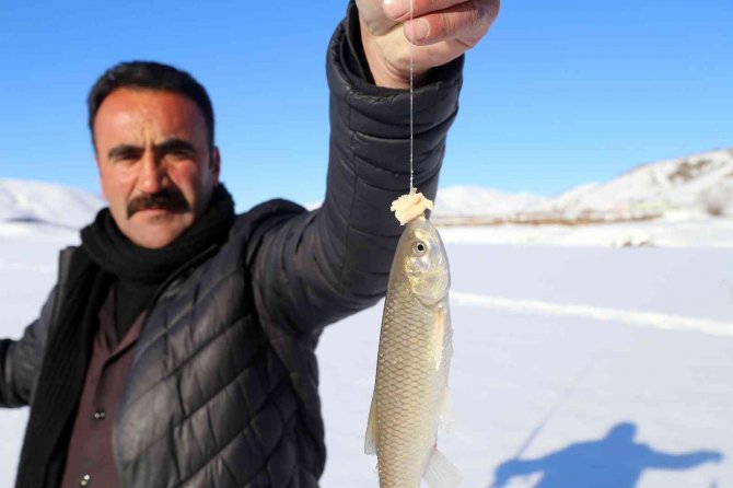 Baraj gölündeki 40 santimlik buzu kazma ile kırıp balık tutuyorlar