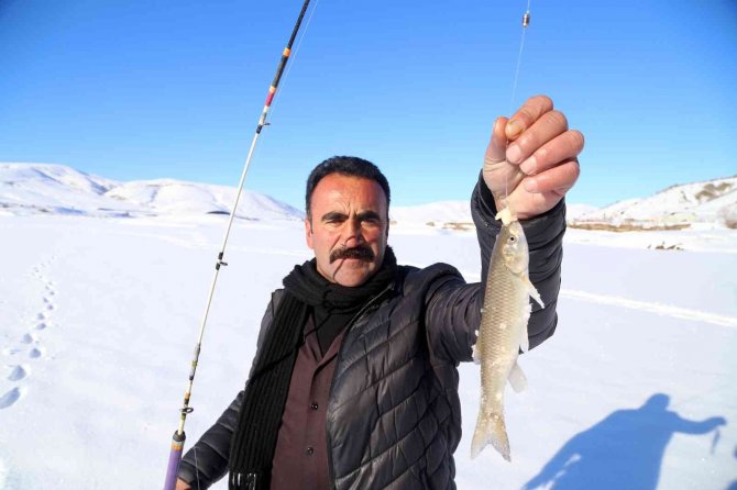 Baraj gölündeki 40 santimlik buzu kazma ile kırıp balık tutuyorlar