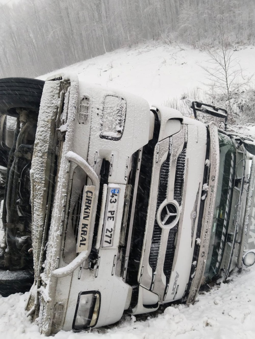 Karda yoldan çıkan TIR, devrildi; 2 yaralı